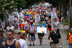 Protesters march with signs, including "Fight for LGBTQ liberation!" and "Defend Trans Rights!"