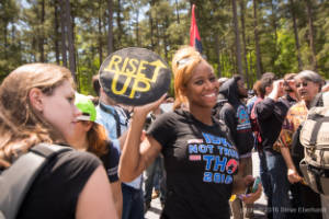 A protester holds a sign that reads, "Rise up"