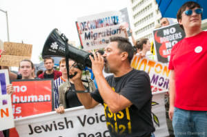 Protester with megaphone in front of others with signs