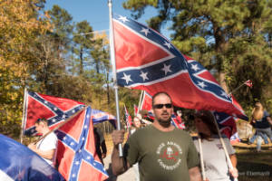 A man holds a Confederate flag