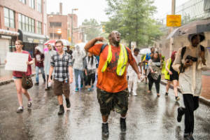 Protesters march through the street in the rain