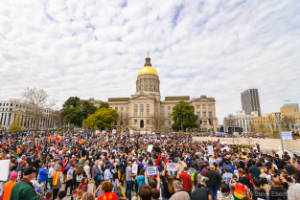 The Georgia State Capitol is seen in the background of a crowd of protesters