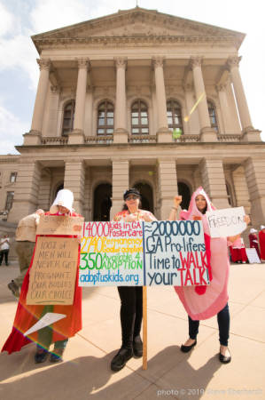Protester dressed as character from Handmaiden's Tale and protester dressed as a vagina, holding signs