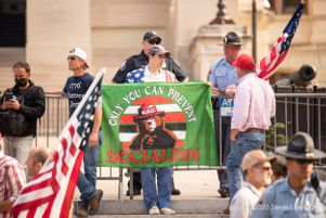 A protester holds a flag that reads, "Only you can prevent socialism"