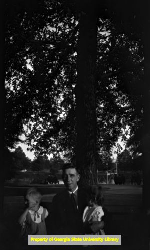 David Lennox Sr. with two children in front of a large tree, Atlanta, Georgia, circa late 1930s or early 1940s