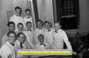 Group of high school boys in formal attire singing around a piano, Atlanta, Georgia, circa late 1930s or early 1940s
