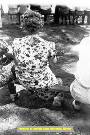 People sitting on benches outside, Georgia, circa late 1930s or early 1940s