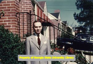 Ernest Welch outside a row of red-brick houses, Atlanta, Georgia (?), April 20, 1953.