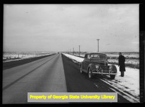 1937 Ford pulled over on the side of a snowy road, circa late 1930s or early 1940s