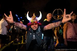 A man in a viking hat enthusiastically walks through the parade