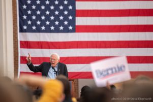 Bernie Sanders holds a finger in the air while speaking to a crowd
