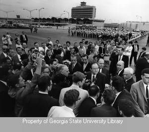 Hubert Humphrey surrounded by journalists at Atlanta Airport