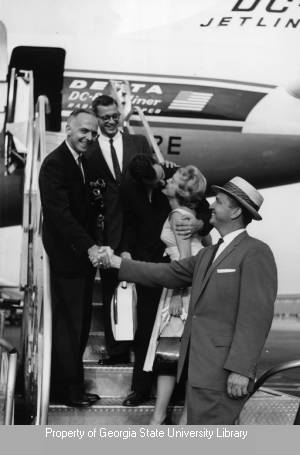 Aubrey Morris and group pose on a jet gangway