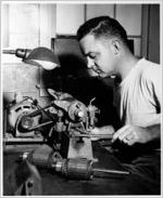 Machinist at performing maintenance on engine parts in Miami, circa 1960s