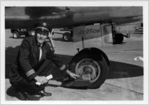 Eastern Air Lines flight crew next to aircraft landing gear, 1976-09