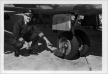 Eastern Air Lines flight crew next to aircraft landing gear, 1976-09