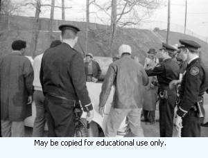 AFSCME Local 1644-led sanitation strike, Atlanta, Georgia, March 1970. These photographs are taken outside the City of Atlanta Construction Department office and warehouse (110-111 Hill Street). Protestors are apparently attempting to block strikebreakers from crossing the picket-line and entering the office area. The photograph series is labeled "Garbage Strike."