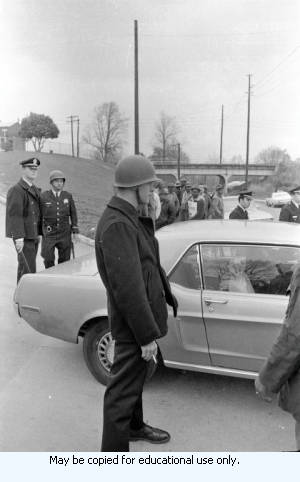 AFSCME Local 1644-led sanitation strike, Atlanta, Georgia, March 1970. These photographs are taken outside the City of Atlanta Construction Department office and warehouse (110-111 Hill Street). Protestors are apparently attempting to block strikebreakers from crossing the picket-line and entering the office area. The photograph series is labeled "Garbage Strike."