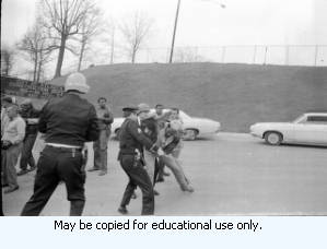 AFSCME Local 1644-led sanitation strike, Atlanta, Georgia, March 1970. These photographs are taken outside the City of Atlanta Construction Department office and warehouse (110-111 Hill Street). Protestors are apparently attempting to block strikebreakers from crossing the picket-line and entering the office area. The photograph series is labeled "Garbage Strike."