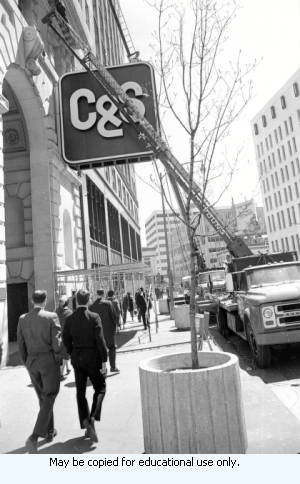 Ladders on trucks reaching up the facade of the Citizens and Southern National Bank building, Marietta Street, at Five Points. Scaffolding is below, Atlanta Georgia, April 1970.