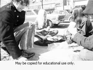 Young adults sitting on Sidewalk April 3, 1970.