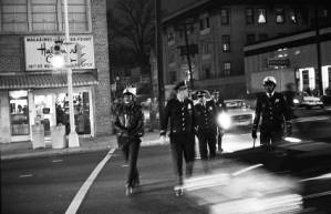 After parking their vehicles at the Firestone Tire, several police walk toward "the Strip" in midtown Atlanta, Georgia, circa 1969.