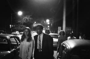 By-standers observing police performing a nighttime anti-drug raid against hippies, Atlanta, Georgia, August 4, 1969.