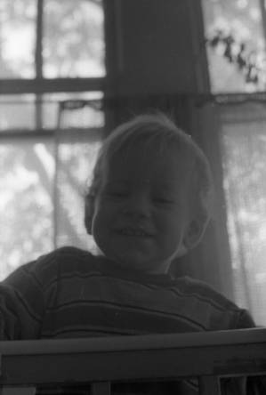 Zachary Coffin looking over his crib, 1969