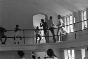 African American community gathered together inside a gymnasium, 1969