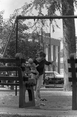Stephanie and Zachary Coffin playing on a swing, 1969