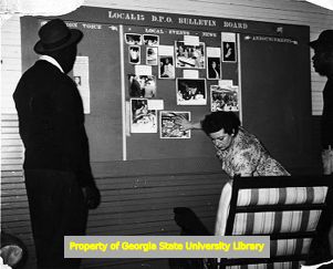 Tobacco workers looking at their labor union bill board, Charleston, S.C., circa 1950s