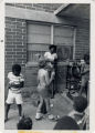 Child speaks into microphone to other children, International Child Day 1977