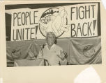 Odis Hyde speaks at podium in front of banner, "People Unite! Fight Back!"