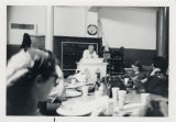 Man stands at podium before a group of seated people
