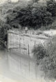Man standing on a wall above a body of water