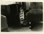 Child holding copy of "People's War People's Army"