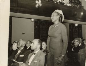 Woman standing to speak at a gathering in a church