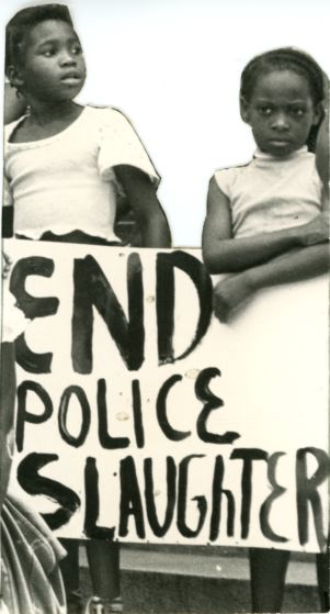 Two children with sign, "End Police Slaughter"