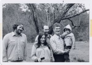 Family poses in front of a tree