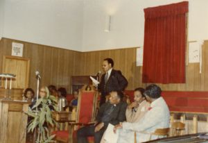 Man speaking at the front of a church
