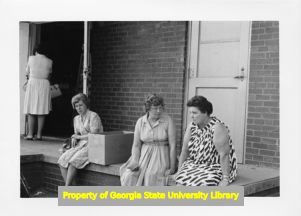 Textile workers sitting on a porch.