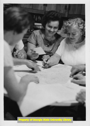 E-Z Mills employees gather around a map of the state of Georgia.