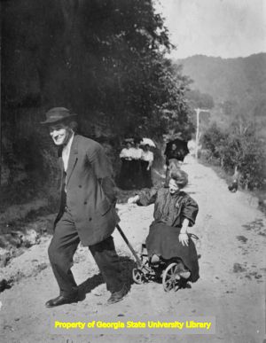 Man pulling woman on a handcart, C. J. French collection