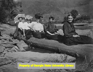 Group posing for picture on log, C. J. French collection