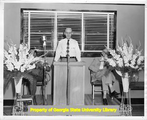 Man speaking at podium during an Amalgamted Clothing and Textile Workers Union meeting