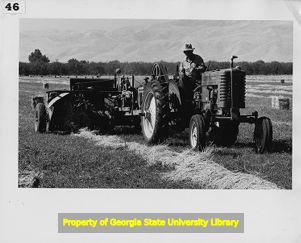 Tractor pulling hay bailing equipment