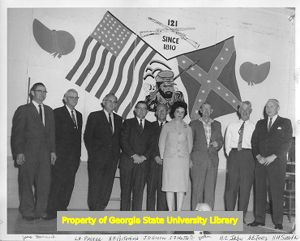 Labor union members standing in front of 121st Infantry Regiment painting.