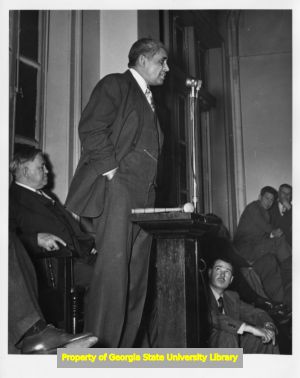 Man speaking at meeting of labor leaders, 1930s