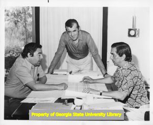 Don Francisco Vega, Jean Laffore, and Deigo del Corral inspect plans for a new hotel, October 1973