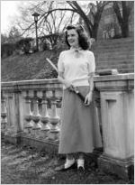 Coed from University of Richmond, posed in quadrangle. In some photos, North Court is visible in the background; in other photos, she is posed in front of an outdoor balustrade. She is photographed wearing a long skirt and cardigan sweater, holding either books or a tennis racquet